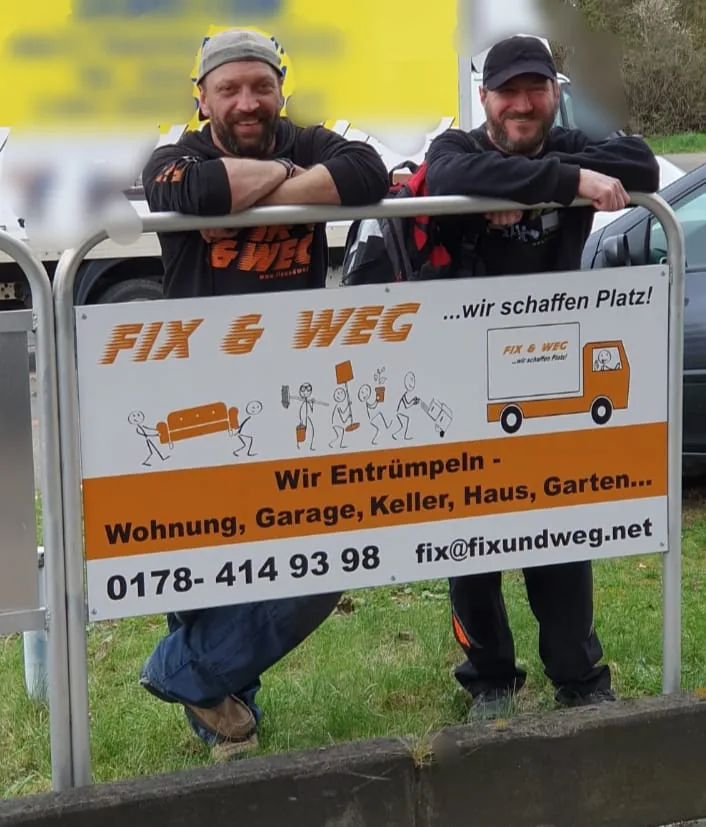 Zwei Mitarbeiter am Firmenschild von Fix und weg