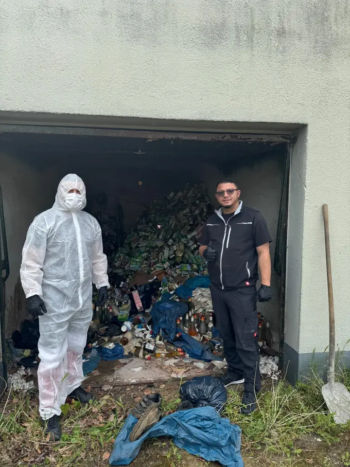 Zwei Mitarbeiter vor einer bis oben gefüllten Garage